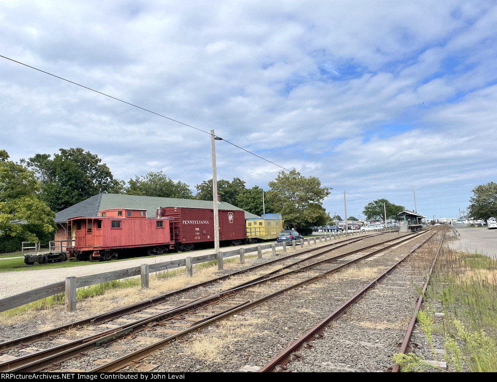 Looking east from the 4th Street Grade crossing along the Greenport Branch. The nakesake station is in the background on the right. These on display railcars on the left belong to the very small RR Museum of LI.